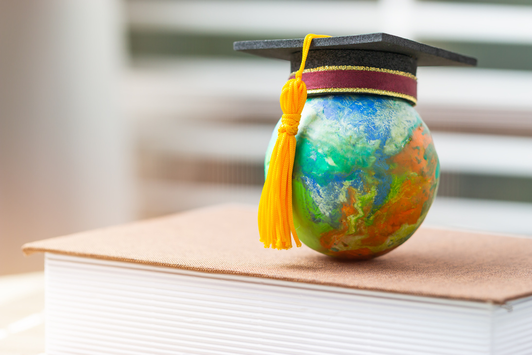 Education to learn study in world. Graduated student studying abroad international idea. Master degree hat on top globe book. Concept of graduate educational for long distane learning anywhere anytime